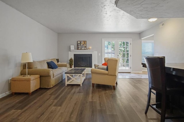 living room featuring hardwood / wood-style flooring, french doors, and a textured ceiling