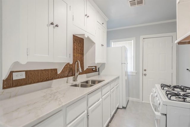 kitchen with light stone counters, sink, ornamental molding, and white cabinets