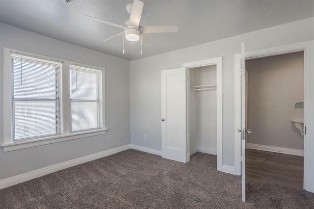 unfurnished bedroom featuring ceiling fan, dark carpet, and a closet