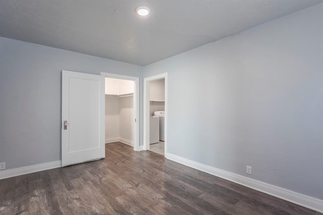 unfurnished bedroom with dark hardwood / wood-style floors, a walk in closet, washer / clothes dryer, and a closet