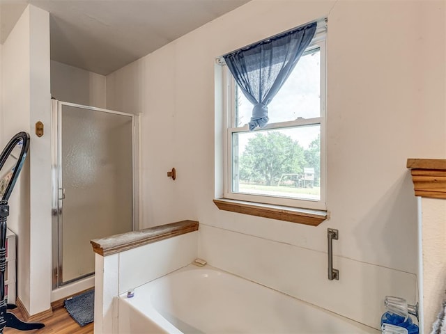 bathroom featuring hardwood / wood-style floors and plus walk in shower