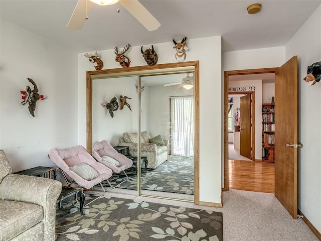 carpeted living room with ceiling fan