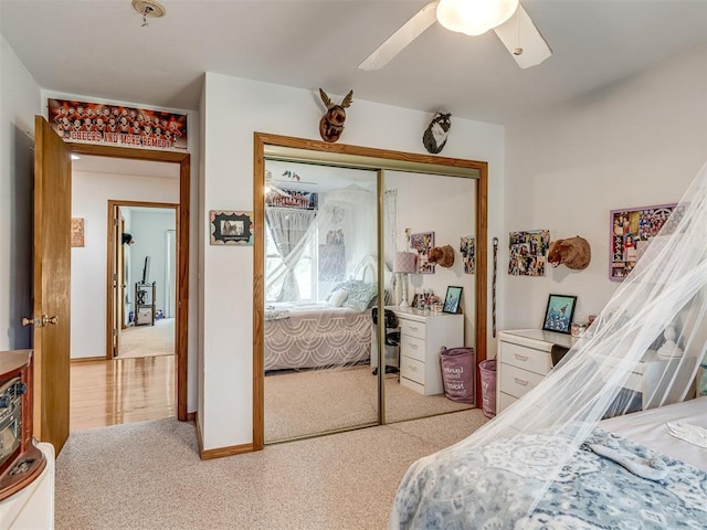 bedroom with ceiling fan, light colored carpet, and a closet