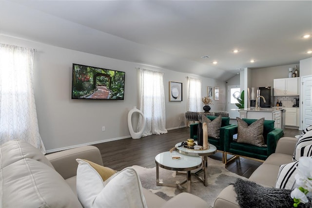 living room with dark hardwood / wood-style flooring, sink, a wealth of natural light, and lofted ceiling