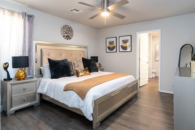 bedroom with ensuite bathroom, dark wood-type flooring, and ceiling fan