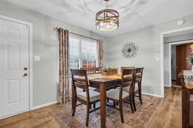 dining room with hardwood / wood-style flooring and a chandelier