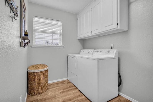 clothes washing area with cabinets, separate washer and dryer, and light hardwood / wood-style floors