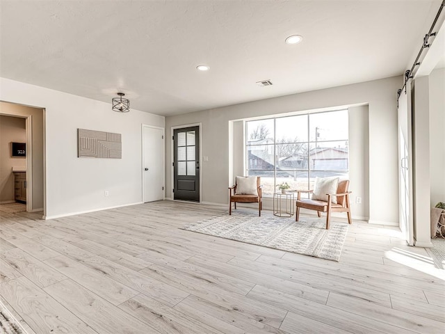 interior space featuring a barn door and light wood-type flooring