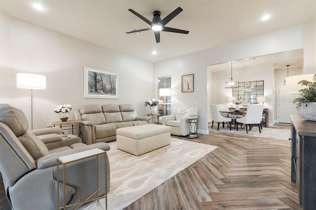 living room with light parquet flooring and ceiling fan with notable chandelier