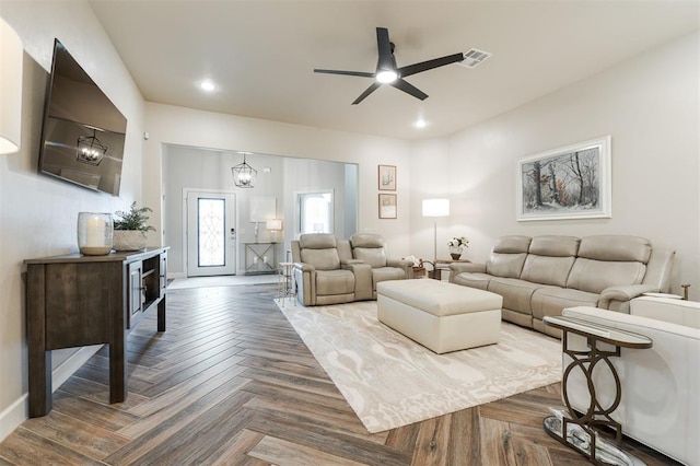 living room featuring dark parquet flooring and ceiling fan