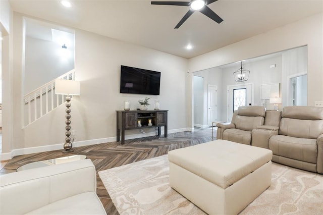 living room with parquet flooring and ceiling fan with notable chandelier