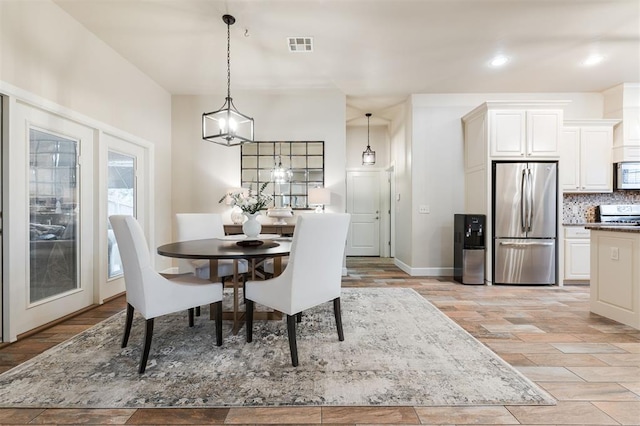 dining area featuring an inviting chandelier and light wood-type flooring