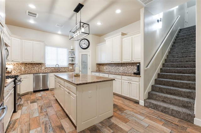 kitchen featuring white cabinetry, stainless steel appliances, and a center island