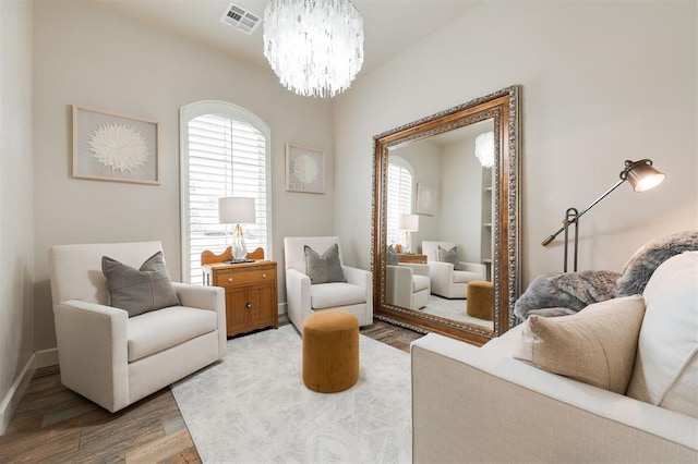 sitting room featuring hardwood / wood-style floors, a wealth of natural light, and a notable chandelier