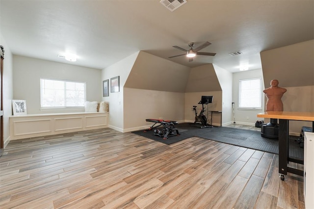 exercise room with vaulted ceiling, light hardwood / wood-style floors, and ceiling fan