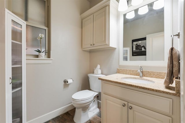 bathroom with hardwood / wood-style flooring, vanity, and toilet