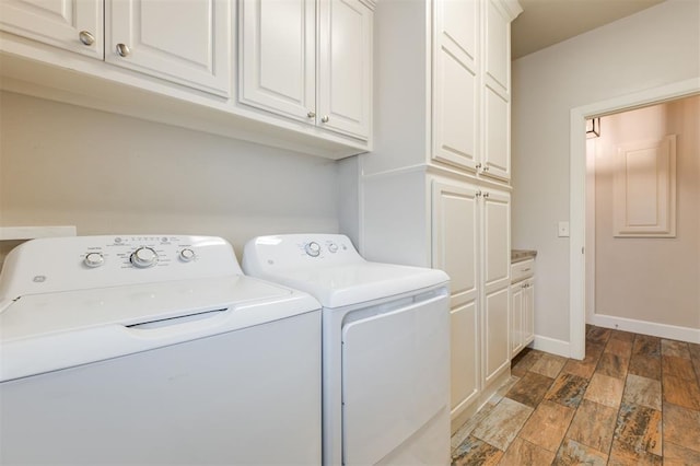 washroom with cabinets, wood-type flooring, and washer and dryer