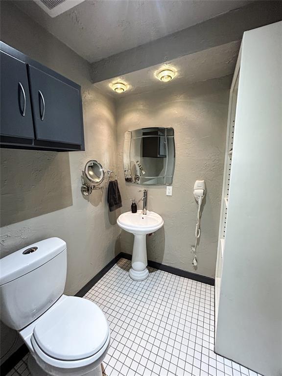 bathroom featuring toilet and tile patterned flooring