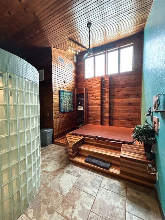 bathroom featuring wooden ceiling and wood walls