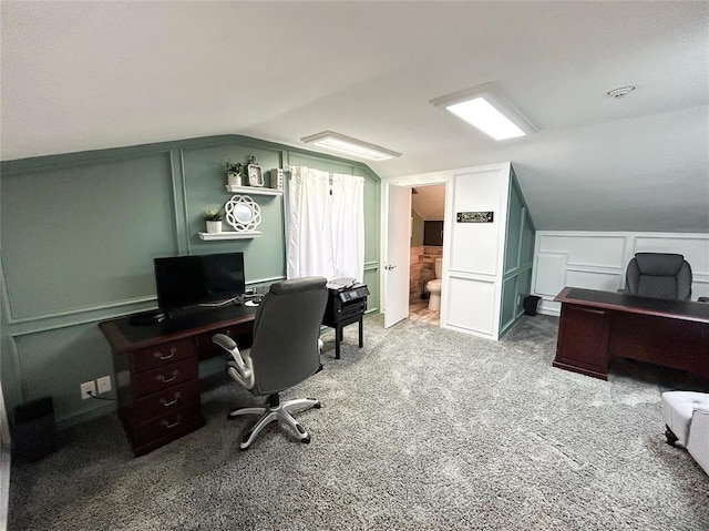 carpeted home office with vaulted ceiling