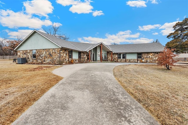 single story home with central AC unit and a front lawn