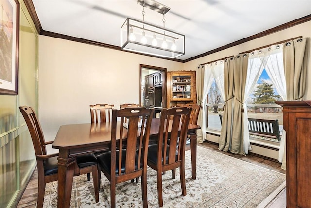 dining area featuring crown molding and hardwood / wood-style flooring