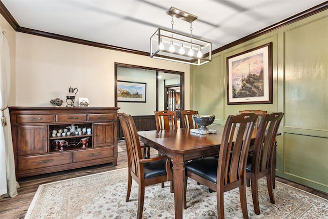 dining space with hardwood / wood-style floors and ornamental molding