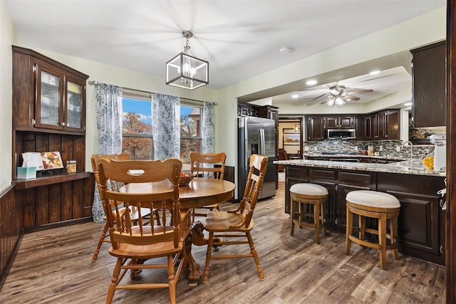 dining room featuring hardwood / wood-style flooring and ceiling fan with notable chandelier