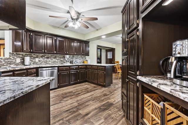 kitchen featuring tasteful backsplash, dark brown cabinets, stainless steel dishwasher, dark hardwood / wood-style flooring, and light stone countertops