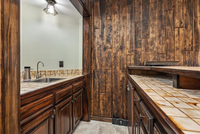 bathroom featuring sink and wooden walls