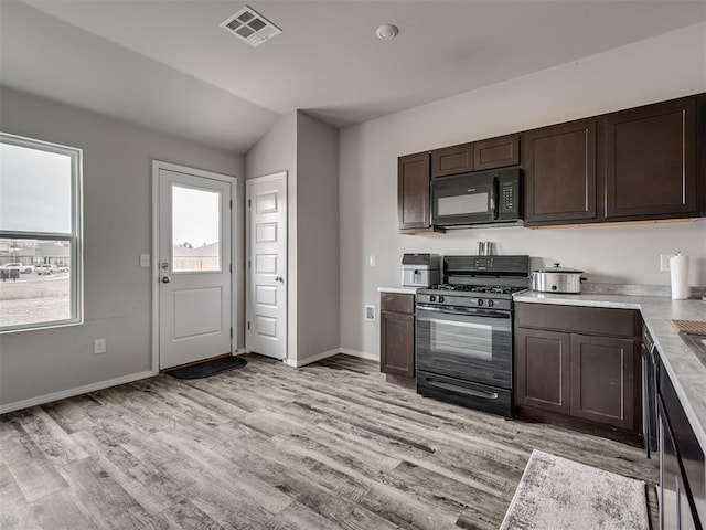 kitchen with lofted ceiling, light wood-type flooring, dark brown cabinets, and black appliances