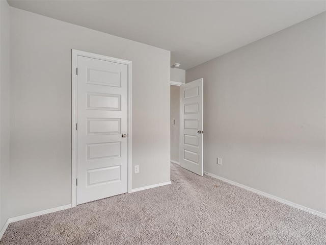 unfurnished room featuring light carpet