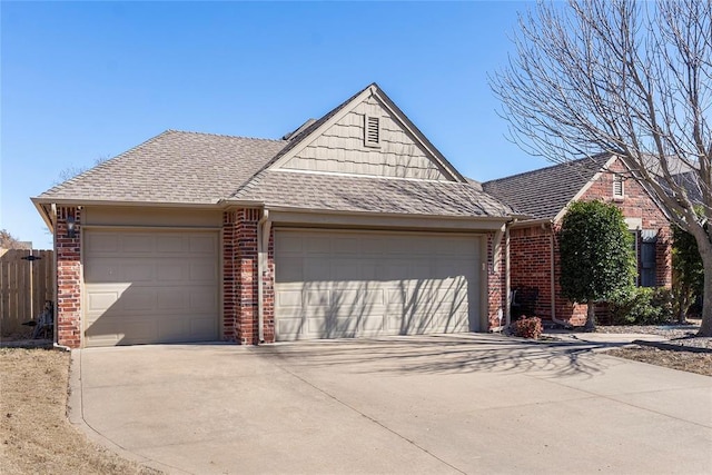 view of front of property featuring brick siding, a shingled roof, fence, a garage, and driveway