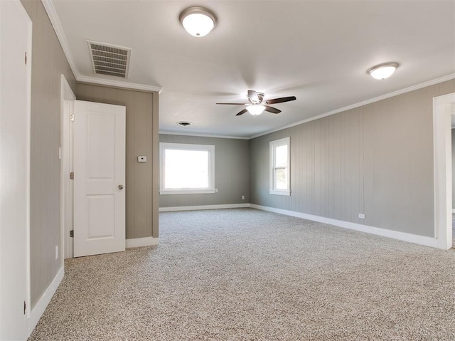 carpeted spare room featuring crown molding and ceiling fan