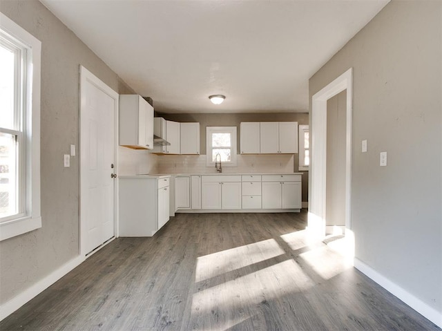 kitchen featuring white cabinetry, decorative backsplash, sink, and light hardwood / wood-style flooring