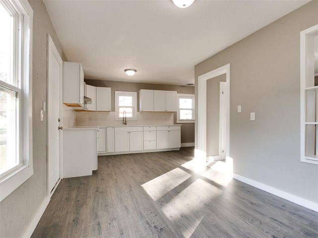 kitchen with white cabinetry, sink, decorative backsplash, and light hardwood / wood-style flooring