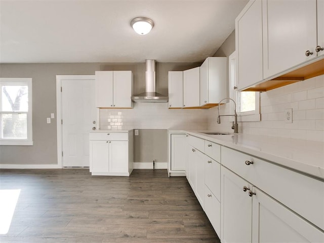 kitchen with white cabinetry, sink, decorative backsplash, and wall chimney exhaust hood