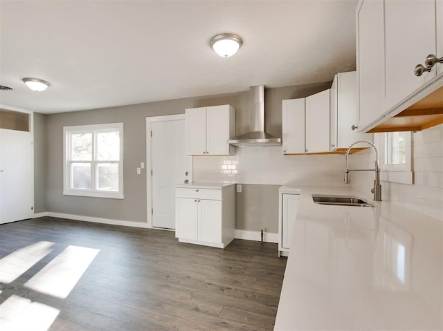 kitchen featuring dark hardwood / wood-style floors, tasteful backsplash, sink, white cabinets, and wall chimney exhaust hood