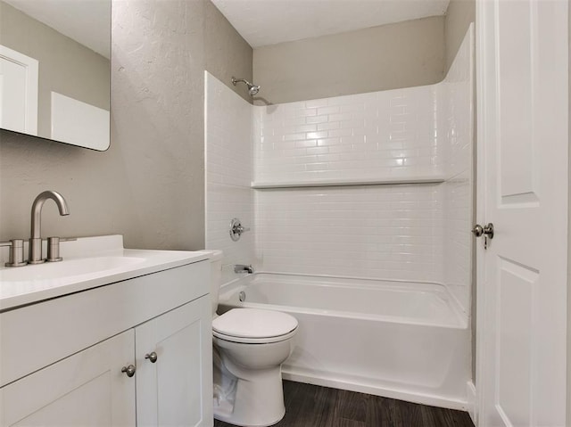 full bathroom featuring wood-type flooring, toilet, vanity, and tiled shower / bath