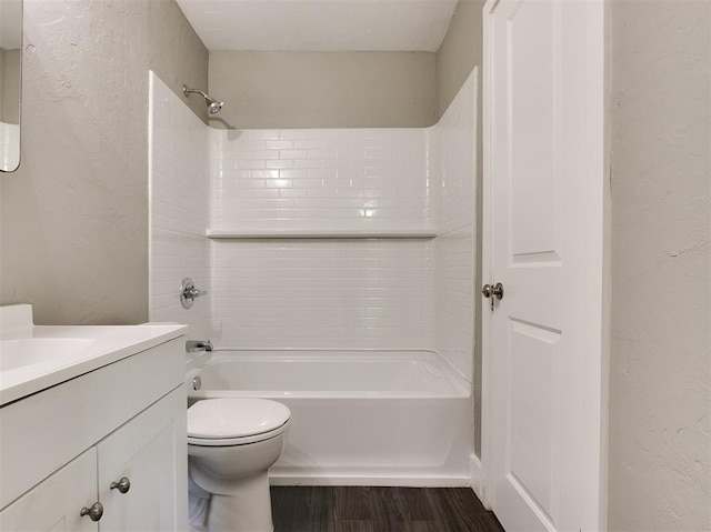 full bathroom with tiled shower / bath, vanity, toilet, and hardwood / wood-style floors