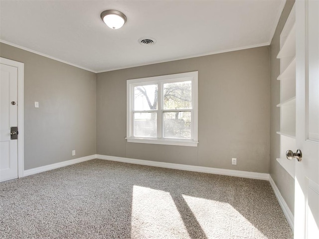 empty room featuring crown molding and carpet flooring