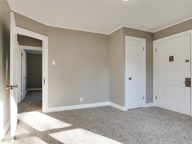 unfurnished bedroom featuring ornamental molding and carpet floors