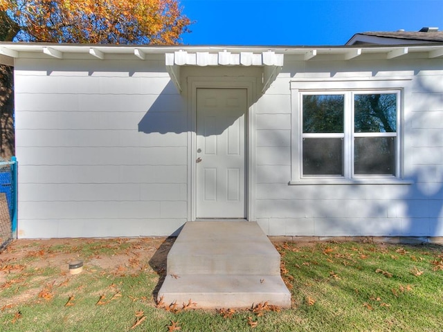 property entrance with a lawn