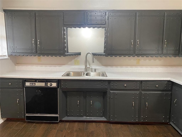 kitchen featuring dark wood-type flooring, gray cabinets, dishwasher, and sink