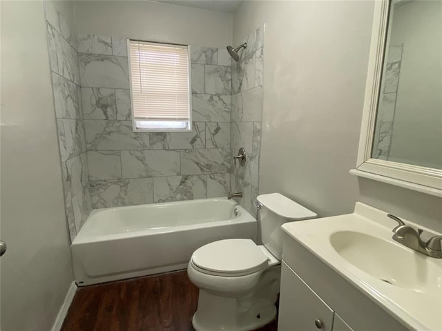 full bathroom featuring vanity, tiled shower / bath, wood-type flooring, and toilet