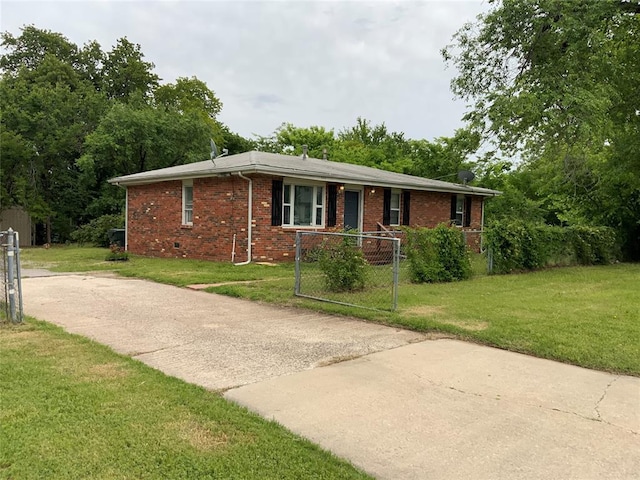view of front of home with a front lawn, brick siding, and fence