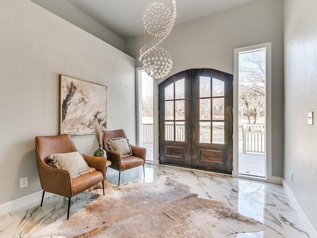 entryway with french doors and a chandelier