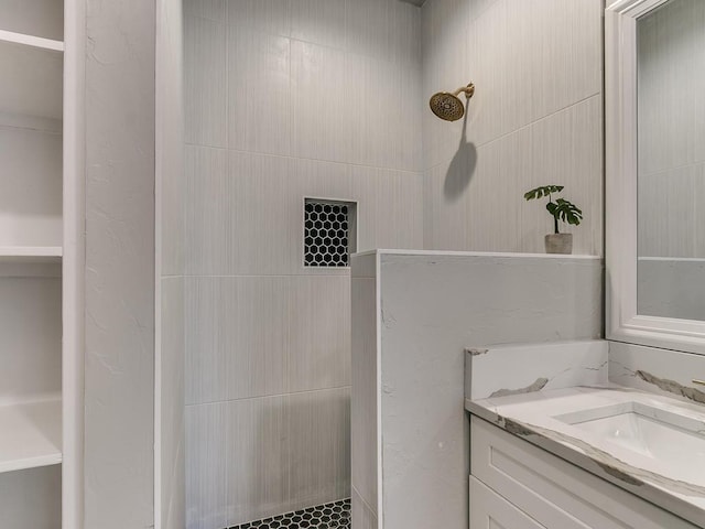 bathroom with vanity and a tile shower