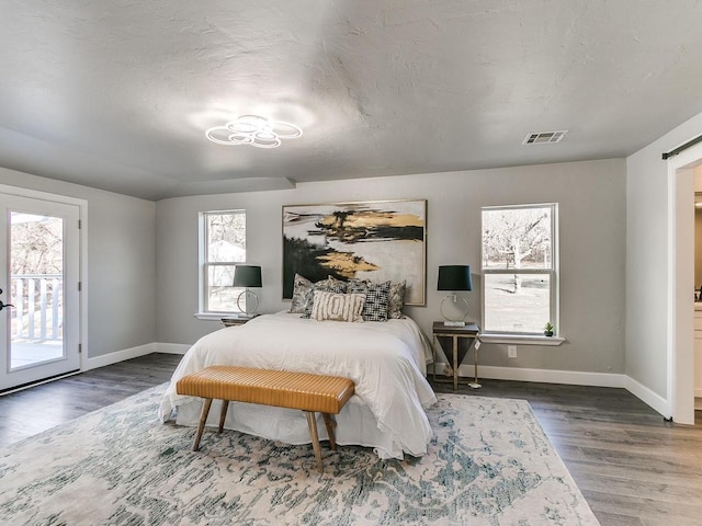 bedroom with access to exterior and dark hardwood / wood-style flooring