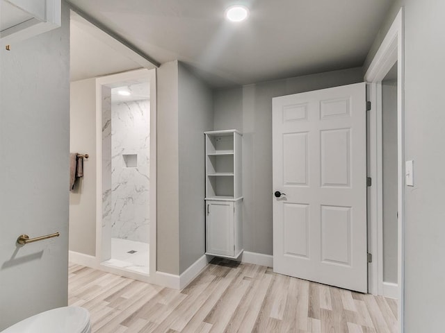 bathroom featuring walk in shower, toilet, and hardwood / wood-style floors